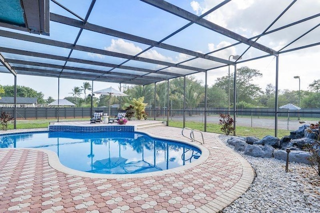 view of pool featuring a patio, glass enclosure, a fenced backyard, and a fenced in pool