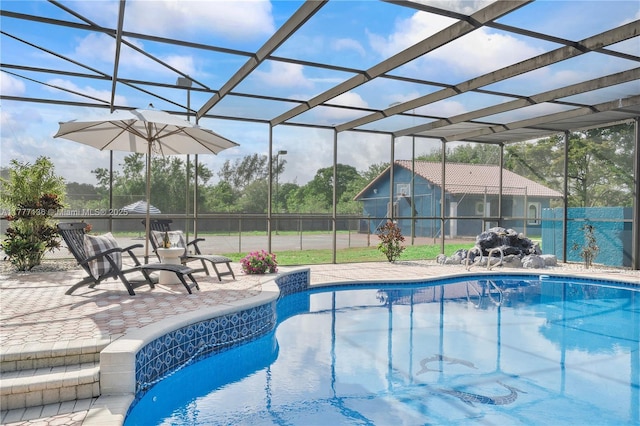 view of pool with a lanai, a fenced in pool, fence, and a patio area