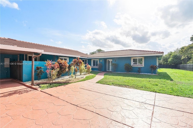 single story home with stucco siding, fence, a front lawn, and a tile roof