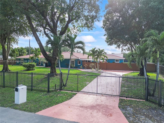 single story home with a front yard, driveway, fence, and a gate