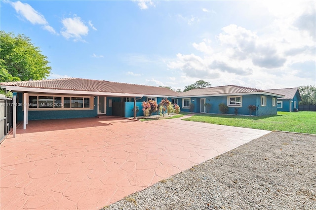 ranch-style house with a front lawn, a tile roof, and stucco siding
