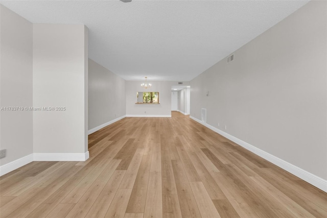10400 NW 30th Ct Unit 203, Sunrise, FL 33322 - unfurnished living room featuring an inviting chandelier, light wood finished floors, and baseboards