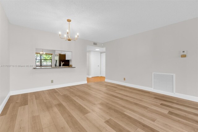 10400 NW 30th Ct Unit 203, Sunrise, FL 33322 - unfurnished living room featuring visible vents, light wood-style flooring, and a notable chandelier