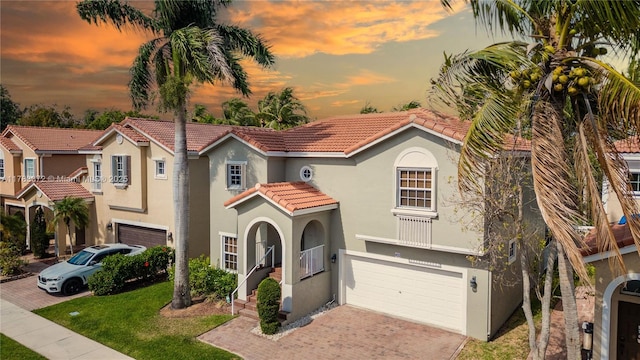 922 NW 127th Ave, Coral Springs, FL 33071 - mediterranean / spanish-style house featuring a tile roof, stucco siding, an attached garage, decorative driveway, and a yard