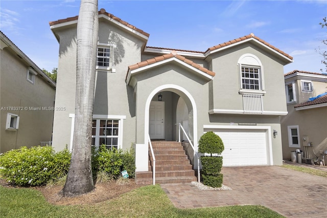922 NW 127th Ave, Coral Springs, FL 33071 - mediterranean / spanish home with a tile roof, stucco siding, decorative driveway, and an attached garage
