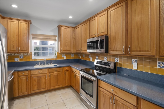 922 NW 127th Ave, Coral Springs, FL 33071 - kitchen with appliances with stainless steel finishes, brown cabinets, dark countertops, decorative backsplash, and light tile patterned flooring