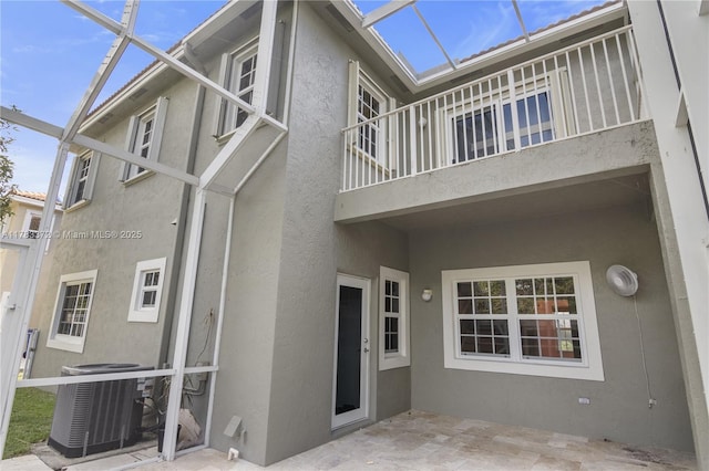 922 NW 127th Ave, Coral Springs, FL 33071 - rear view of house featuring a balcony, stucco siding, a patio area, and glass enclosure