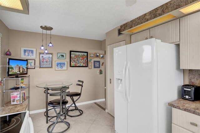 10451 Sunrise Lakes Blvd Unit 401, Sunrise, FL 33322 - kitchen with baseboards, white fridge with ice dispenser, light tile patterned floors, light countertops, and pendant lighting