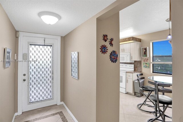 10451 Sunrise Lakes Blvd Unit 401, Sunrise, FL 33322 - entrance foyer with light tile patterned floors, baseboards, plenty of natural light, and a textured ceiling