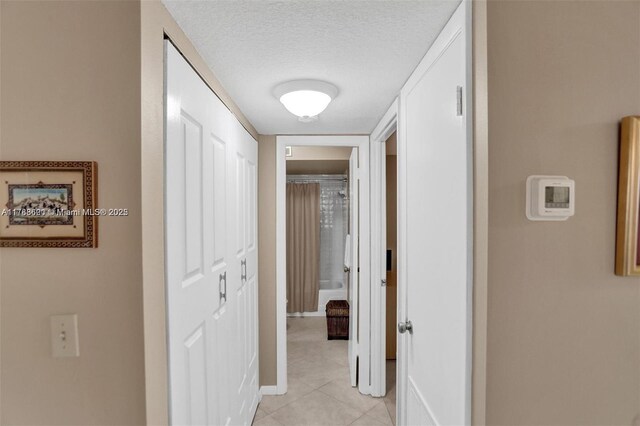 10451 Sunrise Lakes Blvd Unit 401, Sunrise, FL 33322 - hallway featuring a textured ceiling, light tile patterned floors, and baseboards