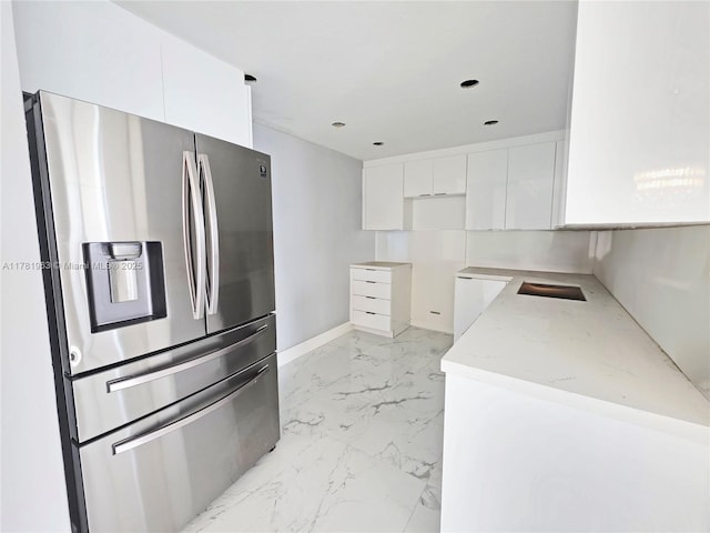 kitchen featuring marble finish floor, modern cabinets, white cabinets, and stainless steel refrigerator with ice dispenser