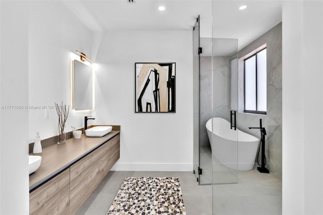 full bath featuring a sink, a soaking tub, recessed lighting, double vanity, and a marble finish shower