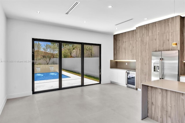 unfurnished living room featuring wine cooler, baseboards, visible vents, and recessed lighting