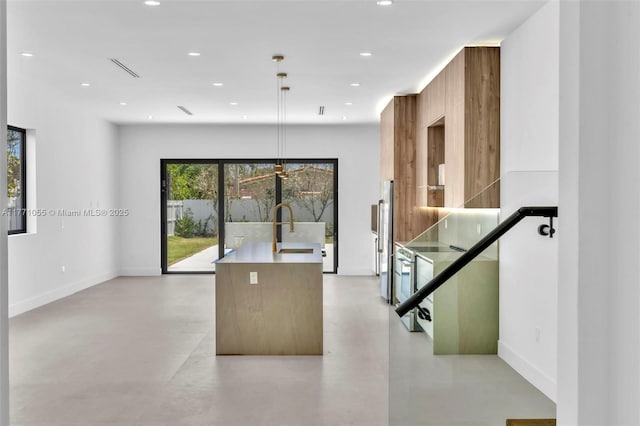 kitchen featuring finished concrete flooring, a sink, modern cabinets, and high end fridge