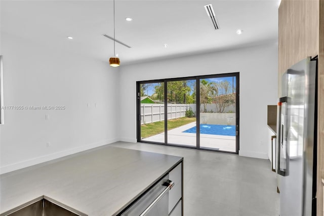 kitchen with recessed lighting, freestanding refrigerator, visible vents, modern cabinets, and pendant lighting