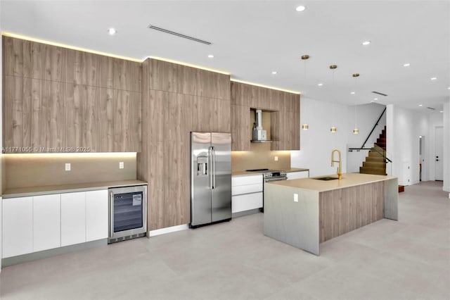 kitchen with a sink, appliances with stainless steel finishes, beverage cooler, and modern cabinets