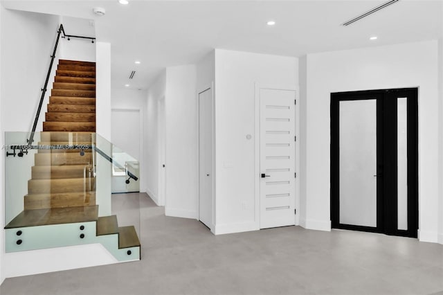 entryway with concrete floors, baseboards, stairway, and recessed lighting
