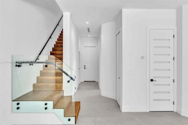 stairs with concrete flooring, baseboards, and recessed lighting