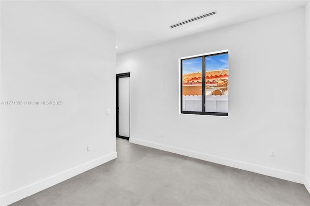 spare room with concrete floors, baseboards, and visible vents