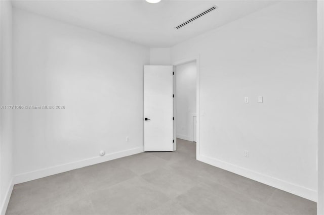 spare room with baseboards and visible vents