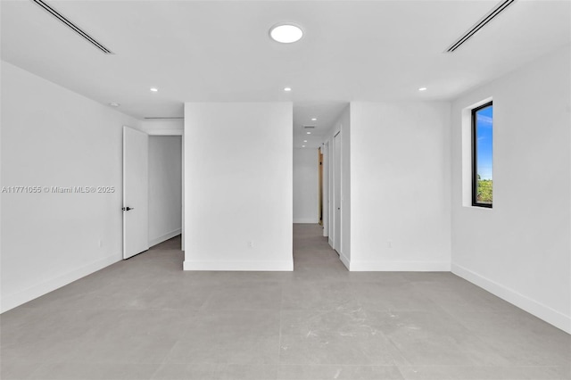 empty room featuring finished concrete floors, baseboards, visible vents, and recessed lighting