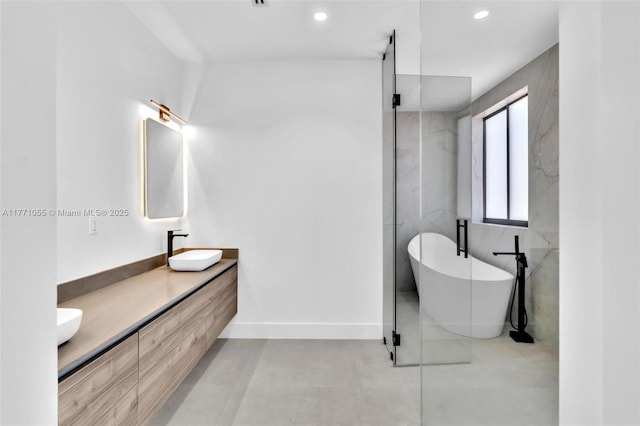 bathroom with a soaking tub, recessed lighting, a sink, a marble finish shower, and double vanity
