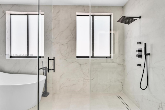 bathroom featuring a freestanding tub and a marble finish shower