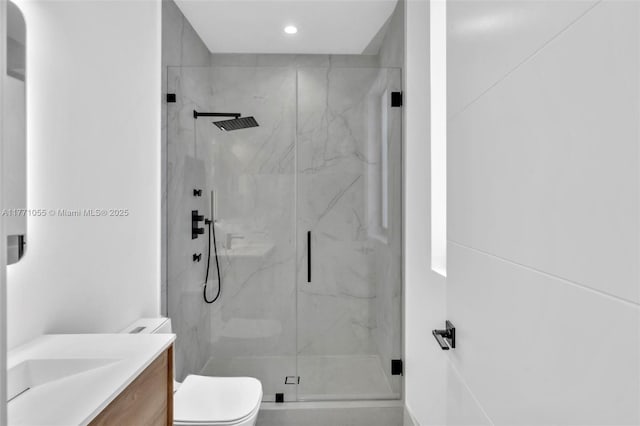 bathroom featuring a marble finish shower, toilet, recessed lighting, and vanity