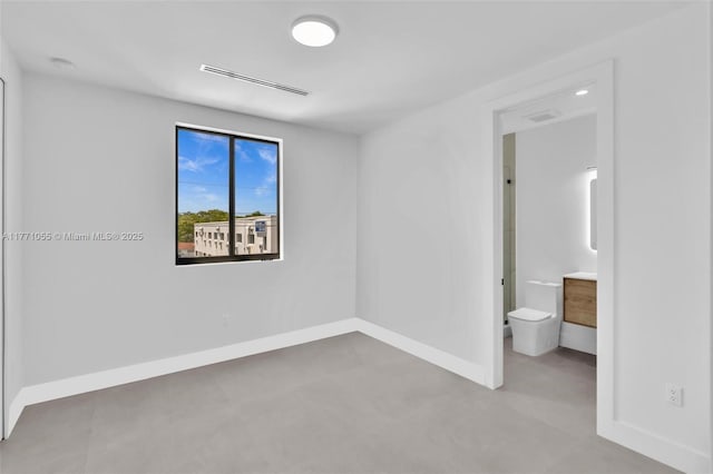 unfurnished bedroom featuring ensuite bathroom, baseboards, and visible vents