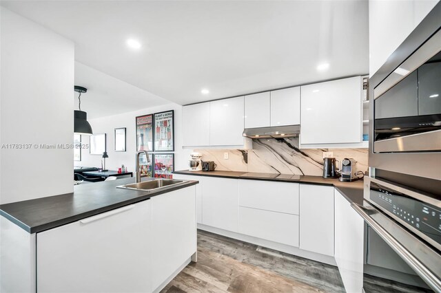 8233 Harding Ave Unit 607, Miami Beach, FL 33141 - kitchen with oven, dark countertops, modern cabinets, white cabinets, and recessed lighting