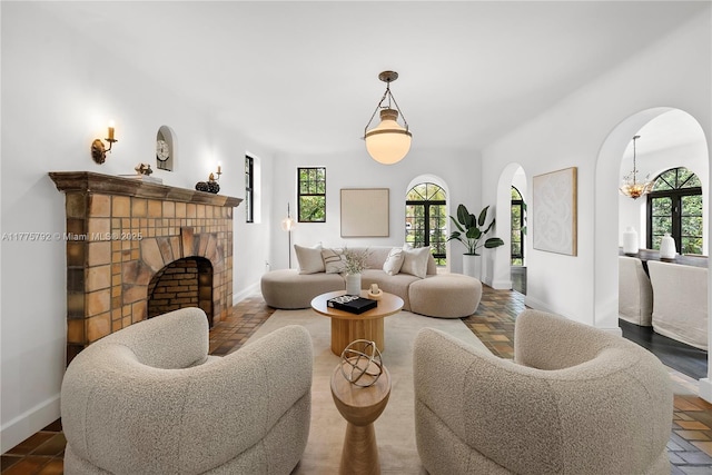 living area with a wealth of natural light, arched walkways, and a notable chandelier