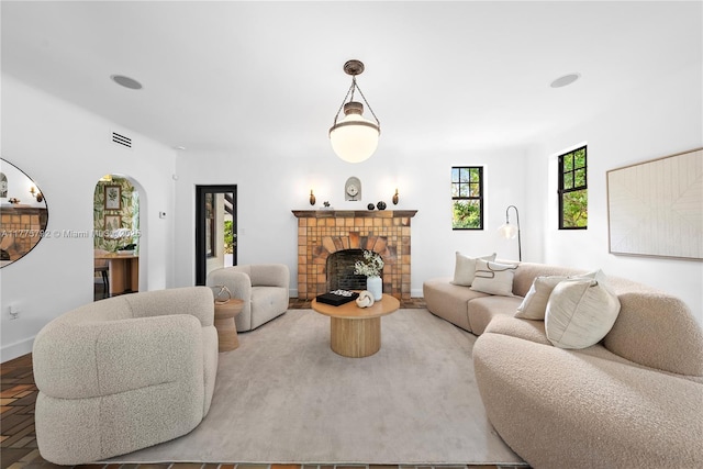 living area with baseboards, a fireplace, and visible vents