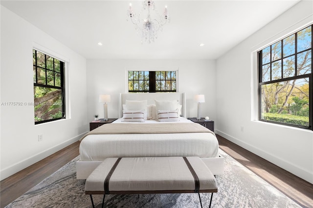 bedroom featuring multiple windows, baseboards, and wood finished floors