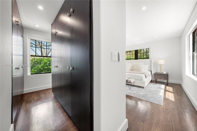 hallway with recessed lighting, dark wood-type flooring, and baseboards