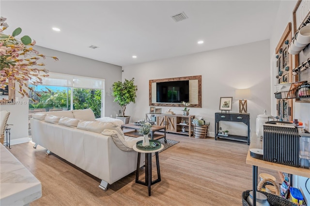 living area featuring recessed lighting, light wood-type flooring, and visible vents
