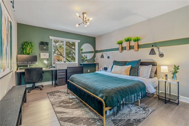 bedroom with a chandelier, wood finished floors, and baseboards