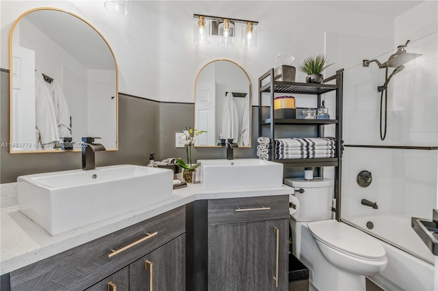 bathroom featuring shower / bath combination, a sink, double vanity, and toilet