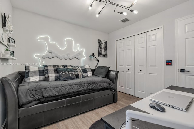bedroom featuring visible vents, wood finished floors, and a closet