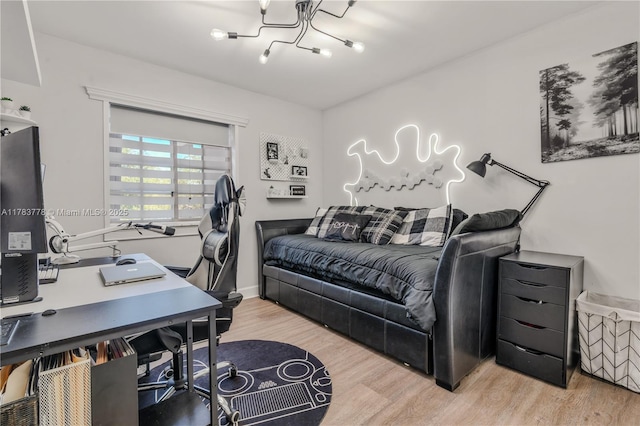 bedroom featuring wood finished floors and an inviting chandelier