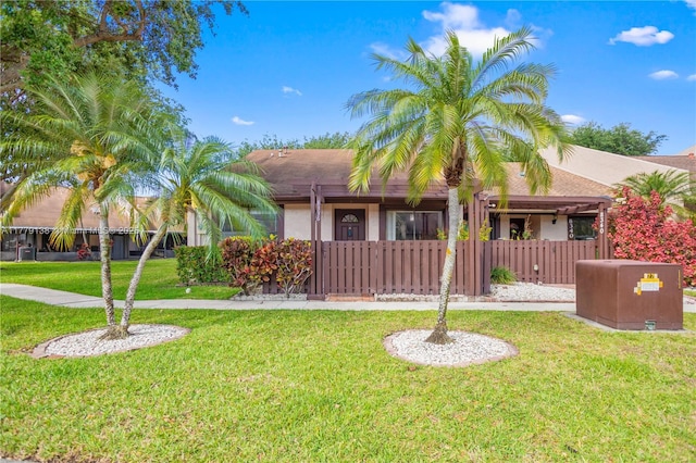 ranch-style home featuring fence private yard, a front lawn, and stucco siding