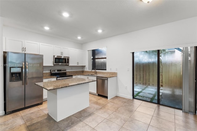 340 NE 208th Ter, Miami, FL 33179 - kitchen featuring white cabinets, a center island, light stone counters, a sink, and stainless steel appliances