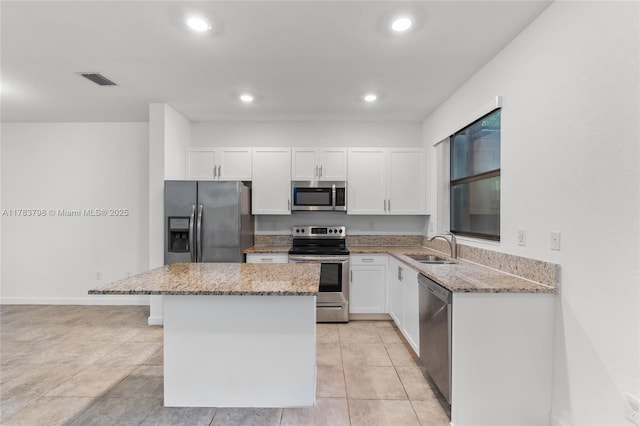 340 NE 208th Ter, Miami, FL 33179 - kitchen featuring light stone countertops, white cabinetry, a kitchen island, a sink, and stainless steel appliances