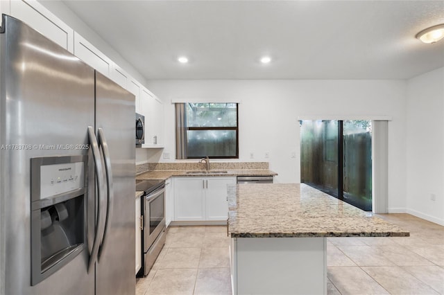 340 NE 208th Ter, Miami, FL 33179 - kitchen with a center island, white cabinets, a sink, a healthy amount of sunlight, and stainless steel appliances