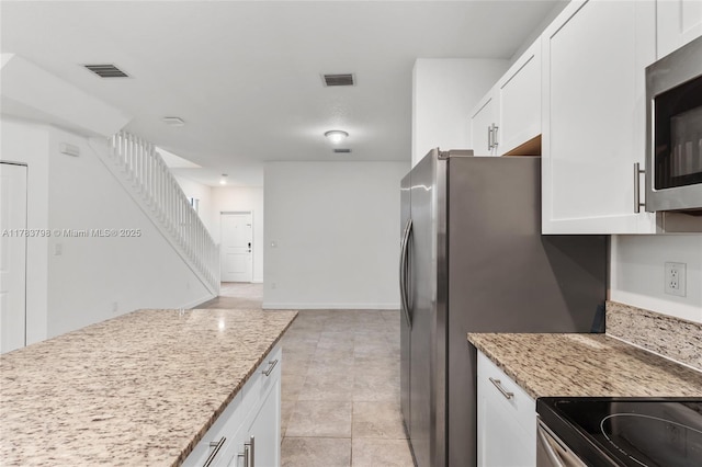 340 NE 208th Ter, Miami, FL 33179 - kitchen featuring white cabinets, light stone countertops, visible vents, and appliances with stainless steel finishes