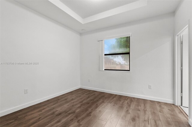 340 NE 208th Ter, Miami, FL 33179 - unfurnished room with a tray ceiling, wood finished floors, and baseboards