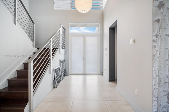 foyer with stairway, french doors, baseboards, and light tile patterned flooring