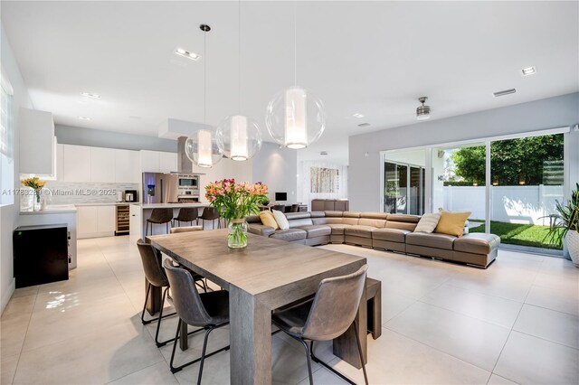dining space featuring light tile patterned floors, visible vents, and beverage cooler