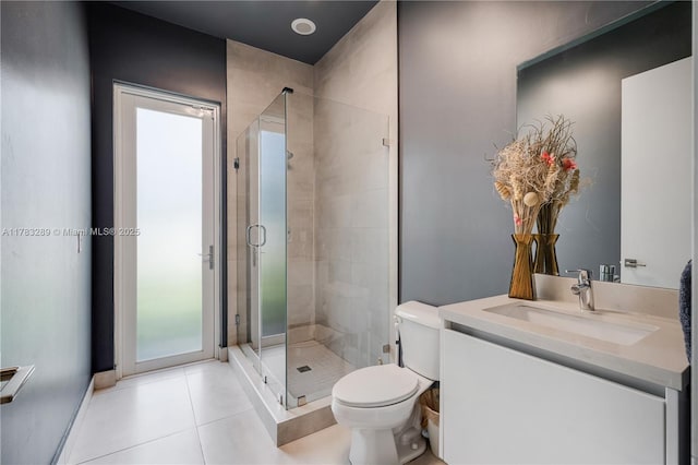 bathroom featuring a shower stall, tile patterned floors, vanity, and toilet