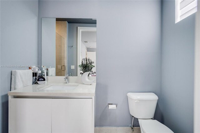 bathroom featuring a shower stall, vanity, and toilet
