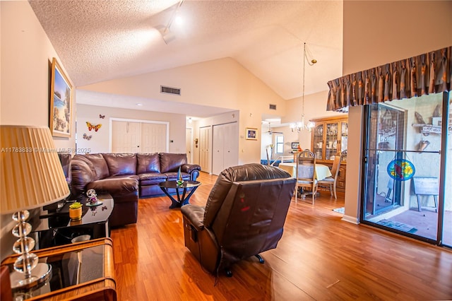 17411 NW 62nd Ct, Hialeah, FL 33015 - living area featuring high vaulted ceiling, a notable chandelier, visible vents, and wood finished floors